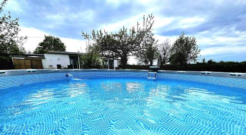 ein großer blauer Pool im Hof in der Unterkunft O' Coin du Beaufol 