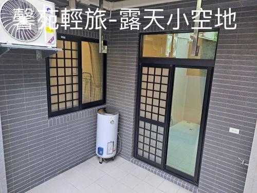 un edificio con dos ventanas y un cubo de basura fuera en 馨苑輕旅Xinyuan Guest House en Beidou