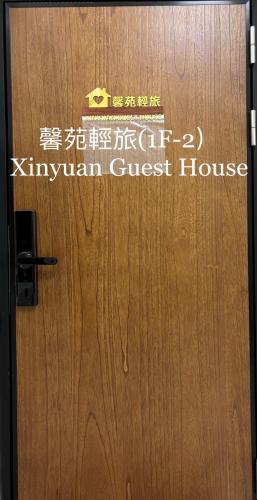un cartel en la puerta de una casa de madera en 馨苑輕旅Xinyuan Guest House en Beidou