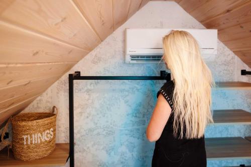 a woman with long blond hair looking at a heater in a room at TRI VODY Demänovská Dolina in Liptovský Mikuláš