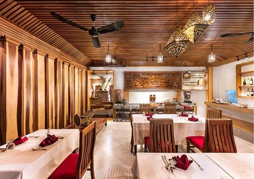 une salle à manger avec deux tables et une cuisine dans l'établissement Cheata Residence, à Siem Reap