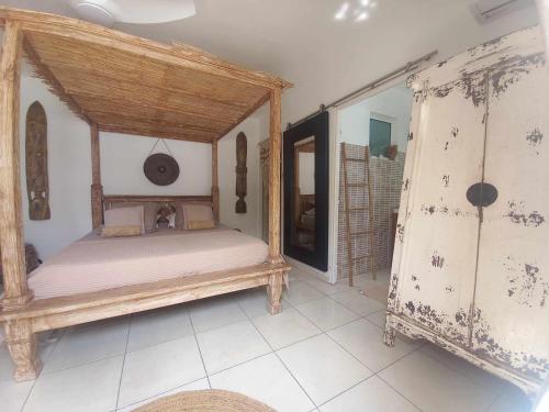 um quarto com uma cama de dossel num quarto em Villa mimosa em La Rivière