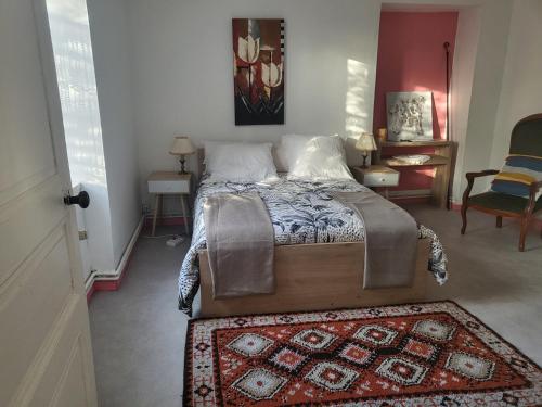 a bedroom with a bed with a rug on the floor at Maison de bourg in Saint-Maurice-les-Brousses