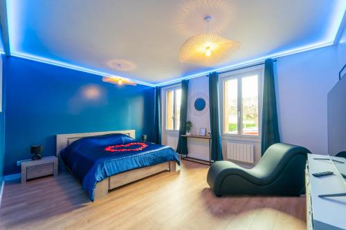 1 dormitorio azul con 1 cama y 1 silla en Suite Eden - Love Room en Coulommiers