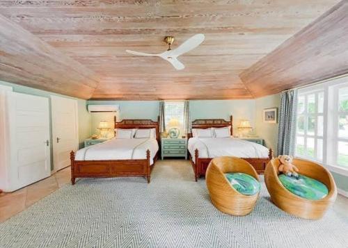 1 dormitorio con 2 camas y ventilador de techo en Villa Oasis Newly Remodeled Luxury Villa with Pool, en Harbour Island