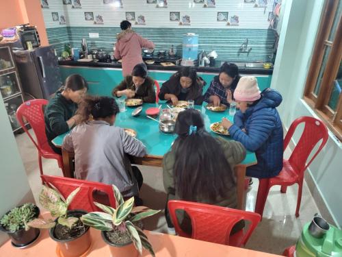 a group of people sitting around a table eating food at Barbet Homestay Kitam in Namchi