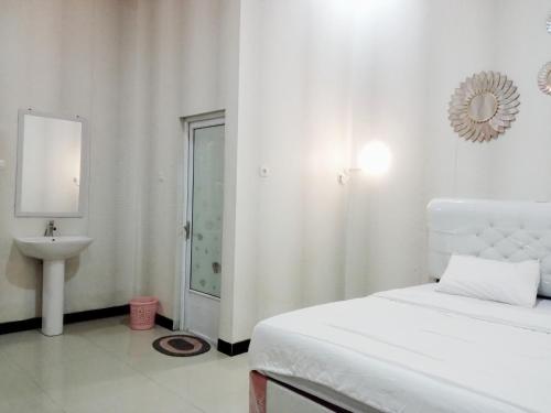 Ένα ή περισσότερα κρεβάτια σε δωμάτιο στο Urbanview Hotel Rifal Home Tegal