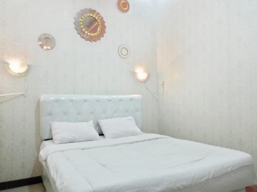 Ένα ή περισσότερα κρεβάτια σε δωμάτιο στο Urbanview Hotel Rifal Home Tegal