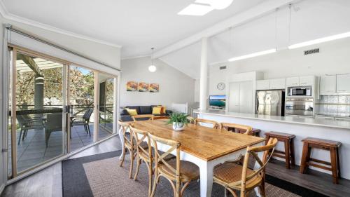 a kitchen and dining room with a wooden table and chairs at Watermark #17 Pool In Complex Accom Holidays in Terrigal