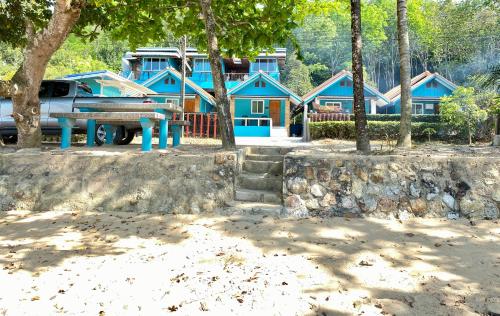 a truck parked in front of a blue house at Ban Tidlay - SHA in Ko Yao Noi