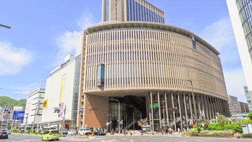 a large building with a tower in a city at Toyoko Inn Kobe Sannomiya eki Shiyakusho Mae in Kobe
