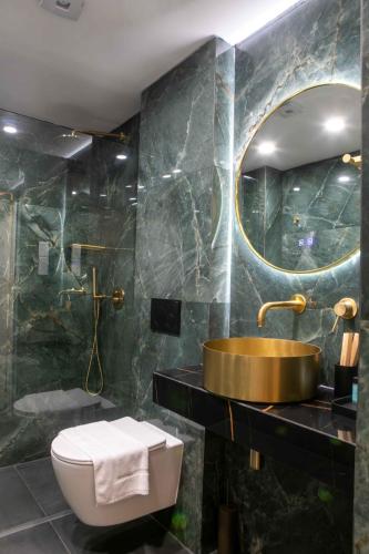 a bathroom with a sink and a toilet and a mirror at Limassol Old Town Mansion in Limassol