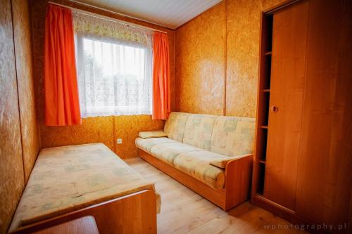 a small room with a couch and a window at Agroturystyka Spokojna domek 5 osobowy in Pogorzelica