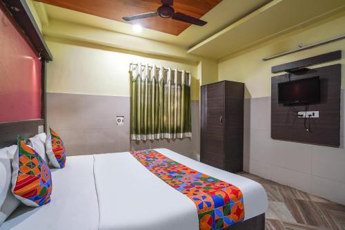 ヴィシャカパトナムにあるFabHotel Sai Nationalのベッドルーム1室(ベッド1台、壁掛けテレビ付)