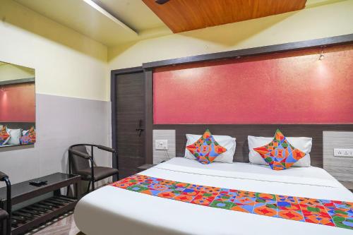 ヴィシャカパトナムにあるFabHotel Sai Nationalの赤い壁のベッドルーム1室(白いベッド1台付)