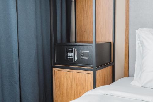 a microwave in a cabinet next to a bed at Best Western Plus Batumi in Batumi