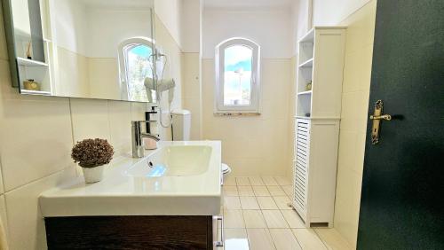 a bathroom with a white sink and a green door at Altura Beach Villa in Altura