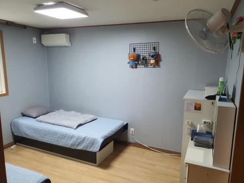 a small room with a bed and a refrigerator at Ilsan Beach Daewangam Park Property in Ulsan