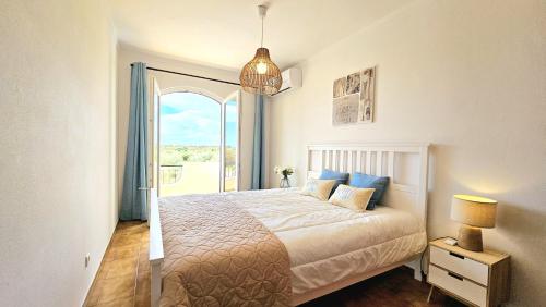 a bedroom with a bed and a large window at Altura Beach Villa in Altura