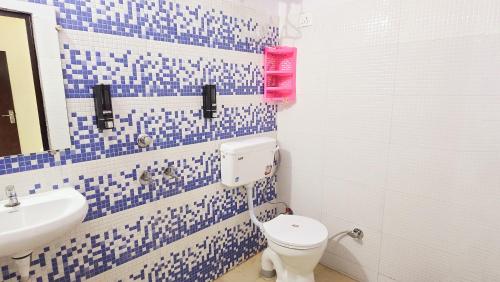 uma casa de banho azul e branca com WC e lavatório em Niketan INN - Near Chanakyapuri Embassy Area em Nova Deli