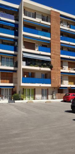 un parking devant un immeuble avec des balcons bleus dans l'établissement Proche de tout prés du centre de golfe juan coin calme, à Vallauris
