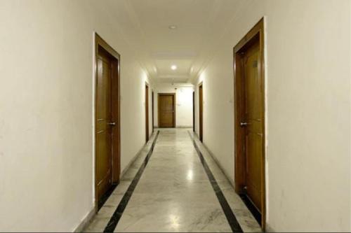 Un pasillo vacío con dos puertas y un pasillo cerrado en OYO Hotel Hyderabad Heights, en Hyderabad