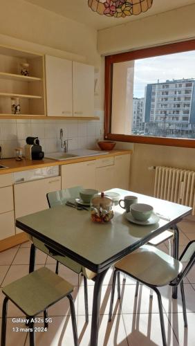 une cuisine avec une table, deux chaises et une table dans l'établissement T2 rénové hyper centre Annecy, à Annecy