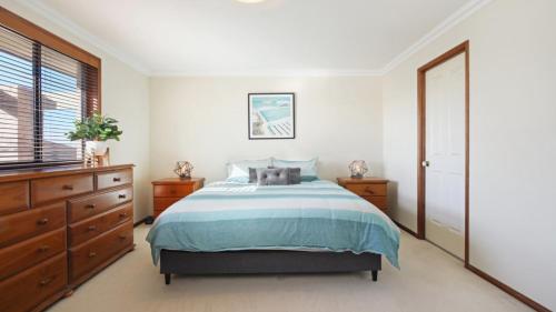 a bedroom with a bed and a dresser and a window at Bayview House Pet Friendly , Spacious Home Accom Property in Blue Bay 