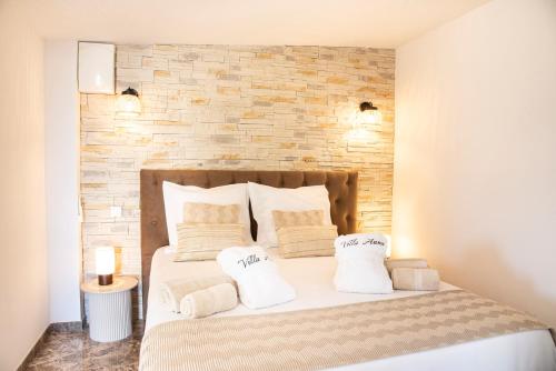 een slaapkamer met een bed met 2 kussens erop bij Chambre d’hôtes Corse Villa Anna in Vescovato
