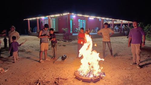 a group of people standing around a camp fire at Aksha Homestay in Sakleshpur