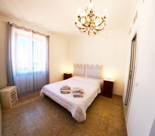1 dormitorio con 1 cama con lámpara de araña en Casa Las Molas en La Maddalena