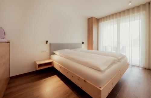 a large bed in a room with a large window at Gutshof Ebner in San Paolo