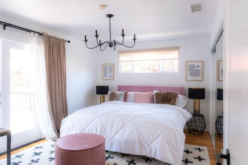 1 dormitorio con cama blanca y lámpara de araña en Sunny and Stylish 4BE 2BA Venice Beach Oasis, en Los Ángeles
