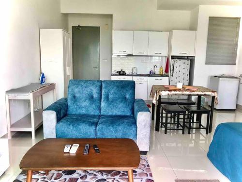 a living room with a blue couch and a table at Cozy Cybersqaure Apex Wifi with free parkin & netflix 107 in Cyberjaya