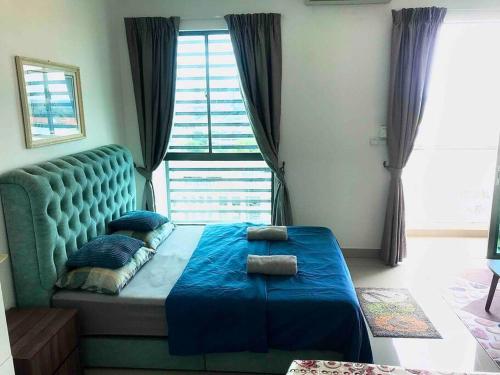 a bedroom with a blue bed with a large window at Cozy Cybersqaure Apex Wifi with free parkin & netflix 107 in Cyberjaya
