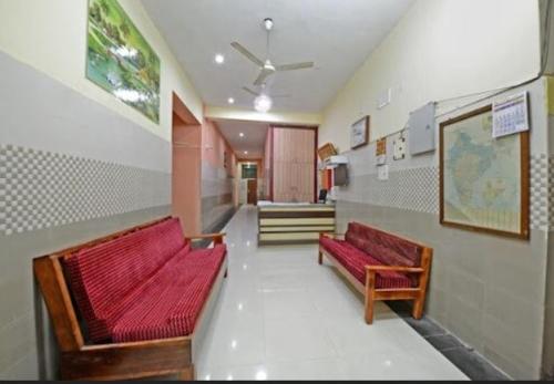 a room with two red benches in a building at THARAN Residency in Vellore