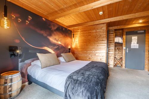 a bedroom with a large bed and a wooden wall at Hôtel Quai des Pontis in Cognac