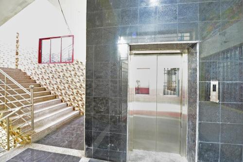 een glazen deur in een gebouw met een trap bij THARAN Residency in Vellore