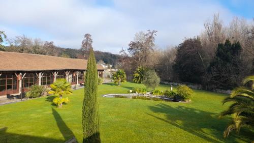a yard with a building and a palm tree at Hôtel Quai des Pontis in Cognac
