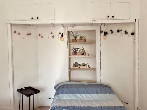 um quarto com uma cama, armários brancos e prateleiras em Superbe Appartement - Proche Paris / Bord de Seine em Argenteuil
