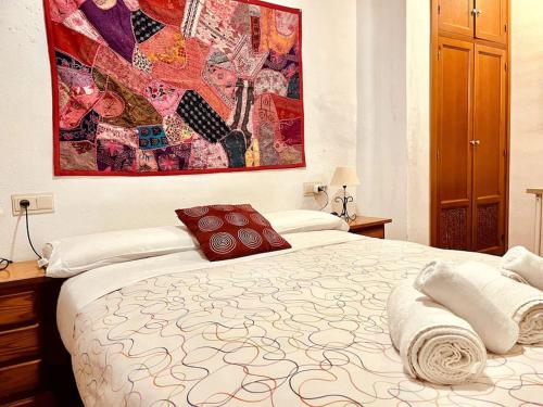 グラナダにあるCharming, spacious Albayzin apartmentのベッドルーム1室(大きな絵画が壁に描かれたベッド1台付)