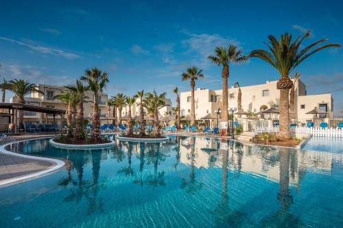 a large swimming pool with palm trees in a resort at Europa Beach Hotel & Spa in Hersonissos