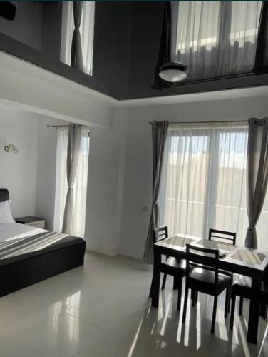 a bedroom with a bed and a table and chairs at Garsonieră in Mamaia Nord