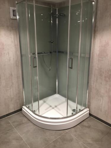 La salle de bains est pourvue d'une douche et d'une cabine de verre. dans l'établissement Apartment with access to pool and sauna, à Porsgrunn