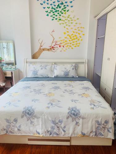 a bedroom with a bed with a painting on the wall at Primrose Homestay Cao Bang in Cao Bằng