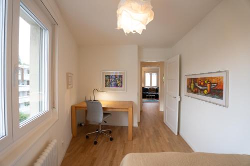 a bedroom with a desk and a window at Jungstay Apartments- near Basel in Basel