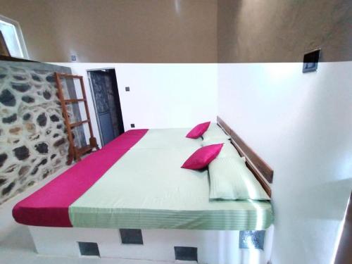 een slaapkamer met een bed met rode kussens erop bij Niwana Resorts kiriella in Kiriella