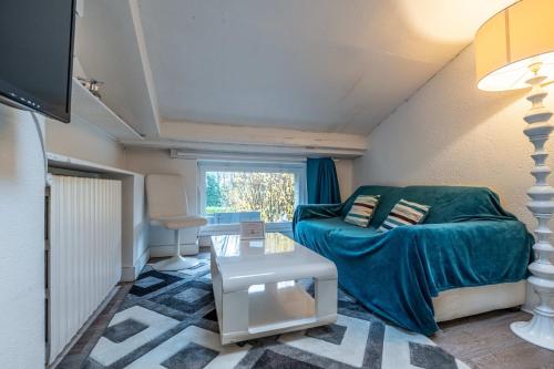 a living room with a couch and a table at Hôtel Quai des Pontis in Cognac
