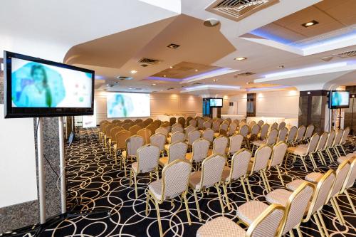 a conference room with chairs and a flat screen tv at Business Hotel Conference Center & Spa in Târgu-Mureş