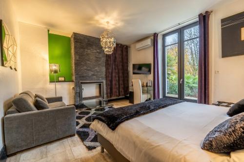 a bedroom with a large bed and a fireplace at Hôtel Quai des Pontis in Cognac